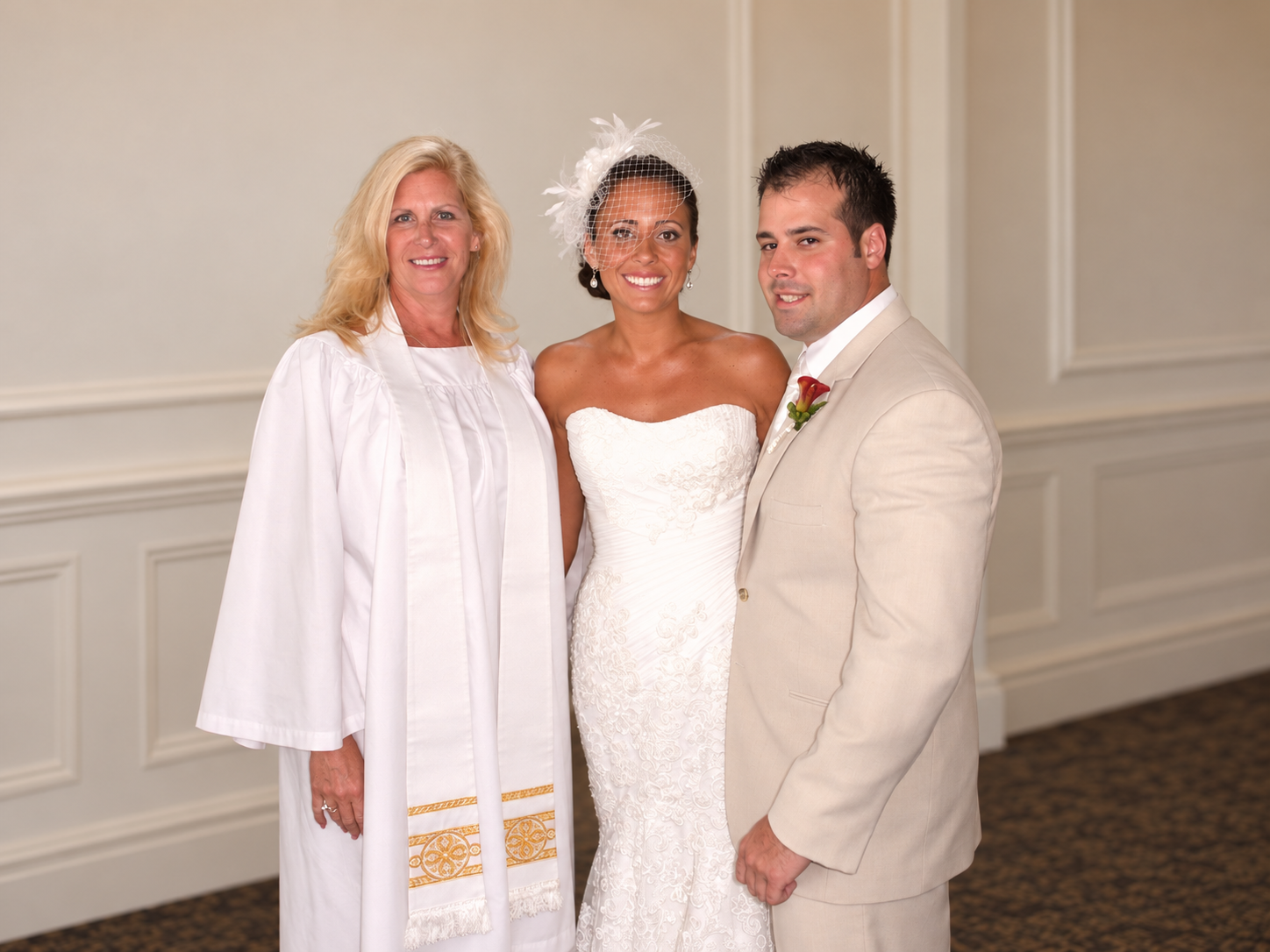 Rev. Riana Milne with a smiling bride and groom after their wedding ceremony